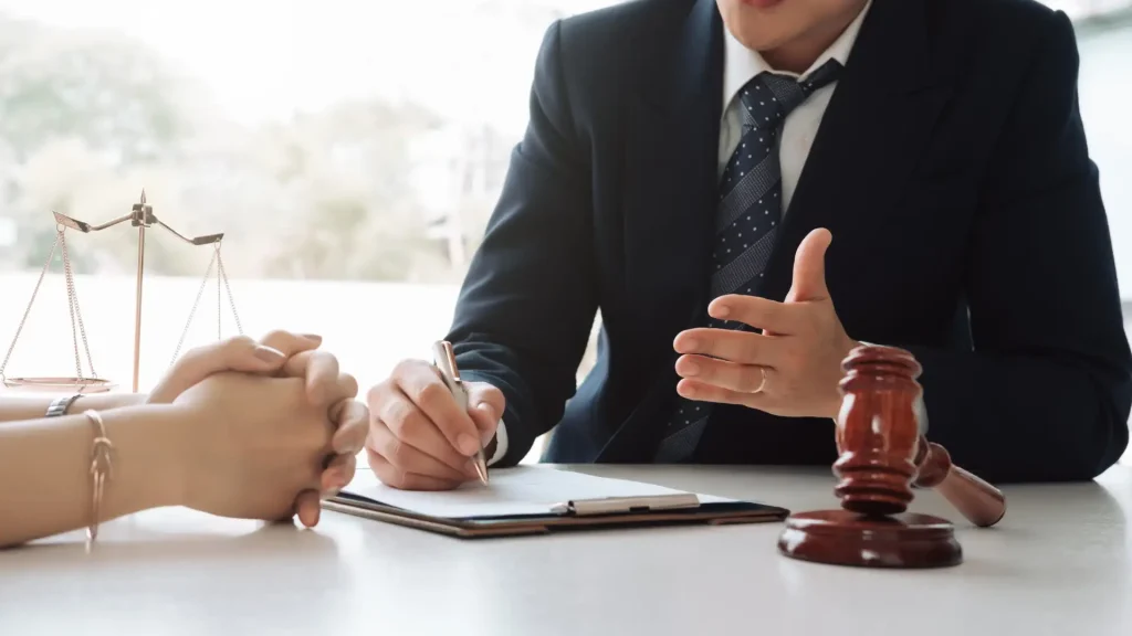 A lawyer gesturing while signing legal documents in an office setting